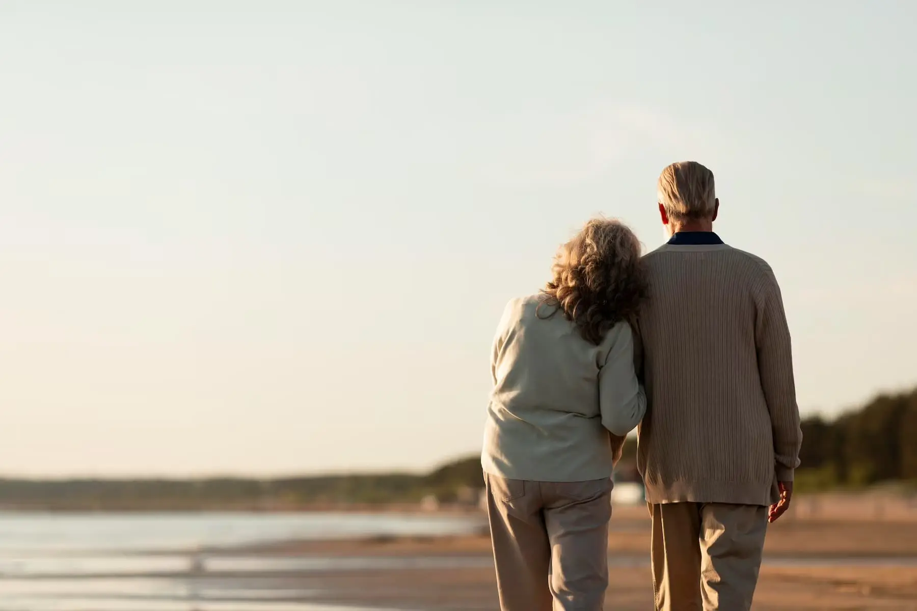 two old couple standing at the beach