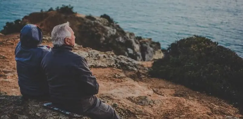 two old couple sitting at the shore