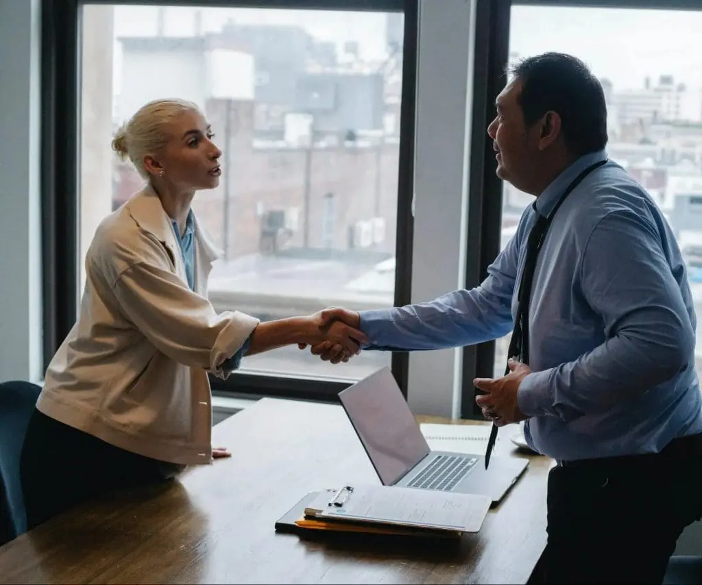 an employer and employee shaking hands while standing