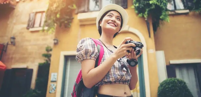 a woman traveller holding a camera