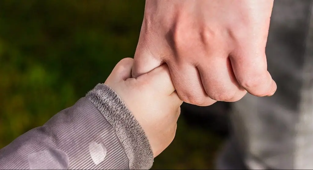 a parent holding hands with a child