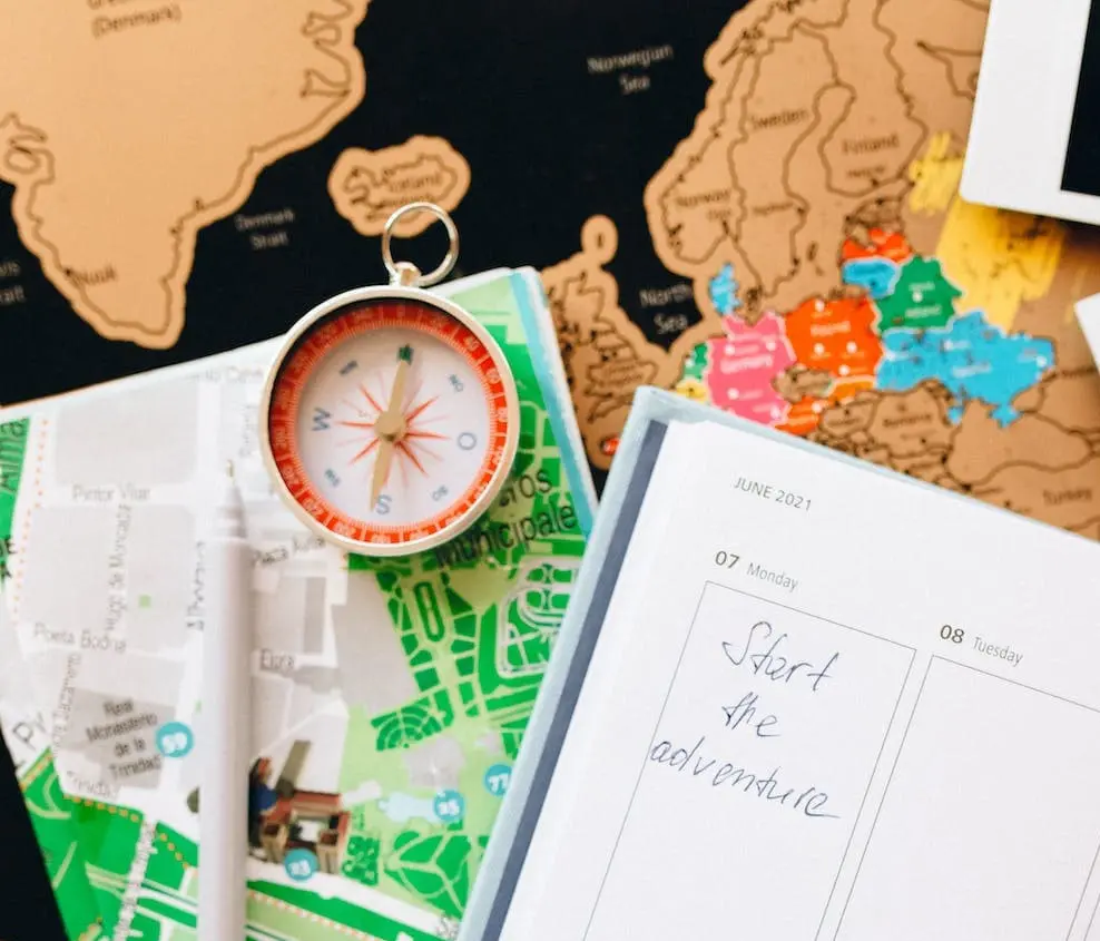 a compass with a map and a notepad