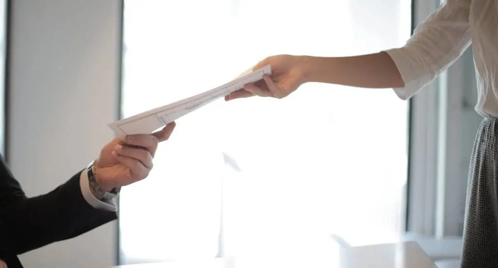 two employees handing documents