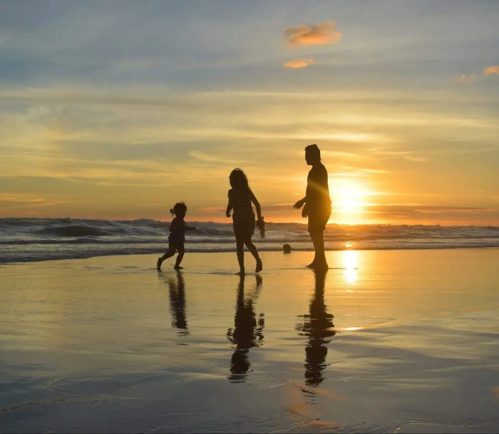 family playing at the beach