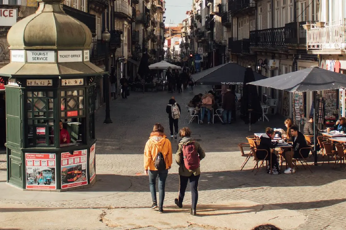 People walking by newsagent on street in Portugal