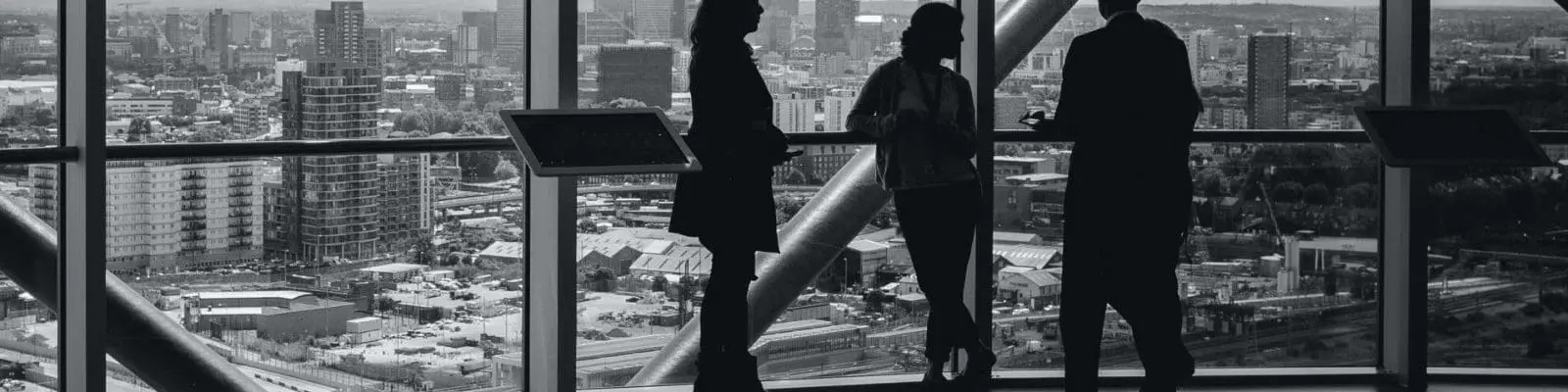 people standing inside a city building overlooking canary wharf