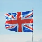 red, white and blue flag flying against a blue sky