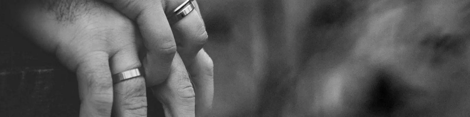 an older couple wearing wedding rings and holding hands