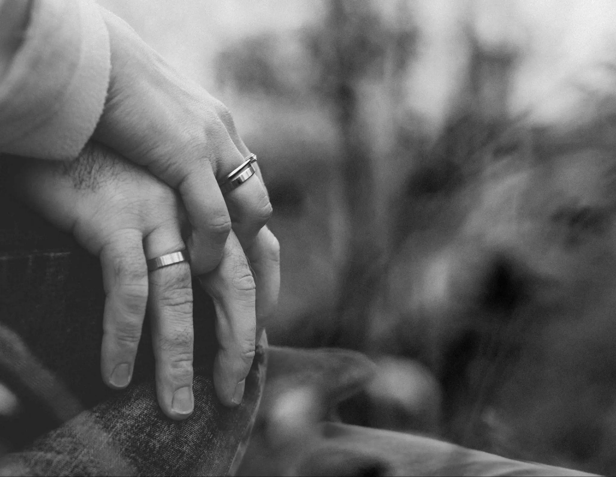 an older couple wearing wedding rings and holding hands