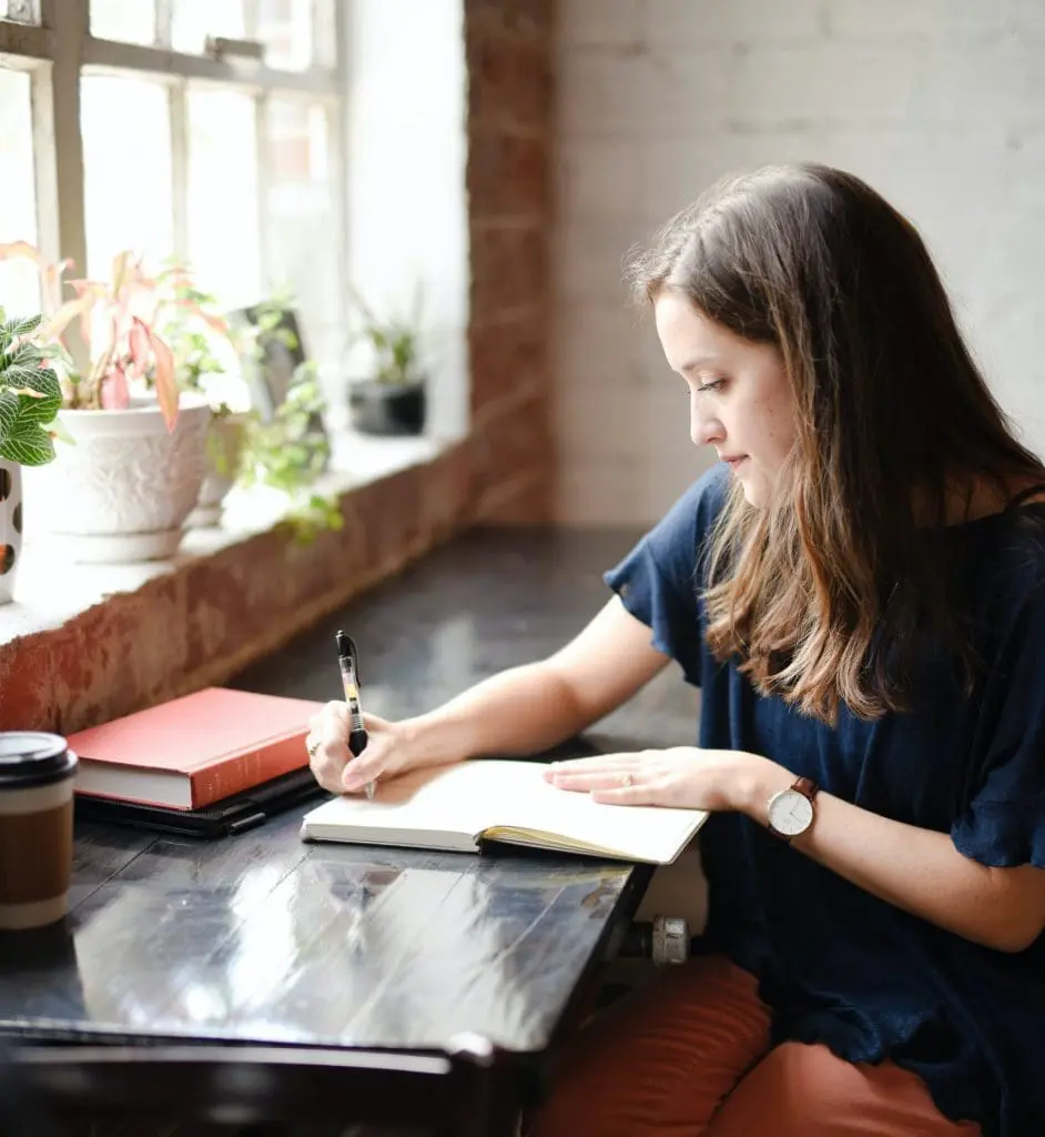 woman writing a letter at a table