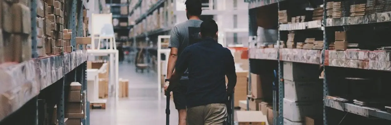 Two people walking in a large warehouse