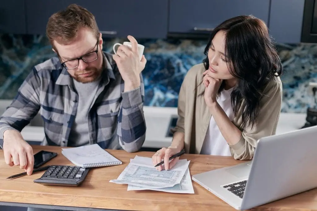 couple looking at bills and calculator on table