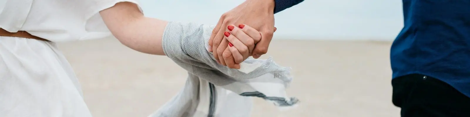 a couple holding hands at the beach
