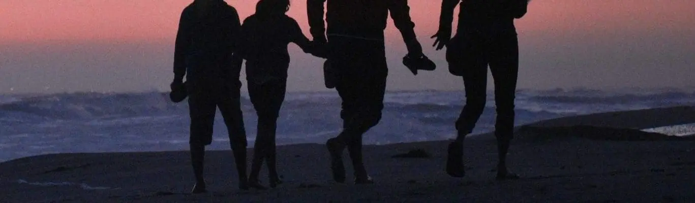 silhouette of family standing on a beach