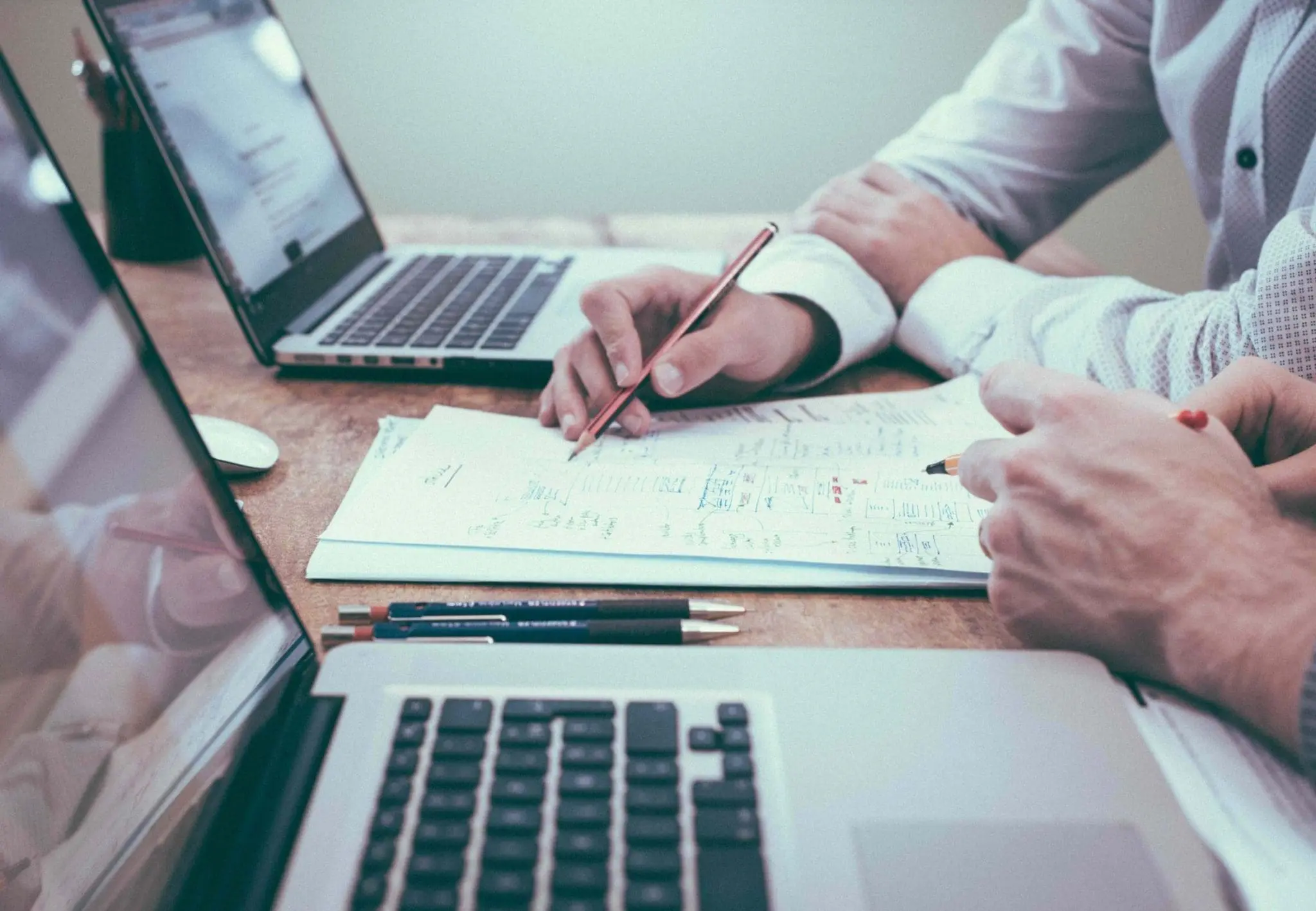someone writing on a desk with a laptop beside them as an example of the english language test