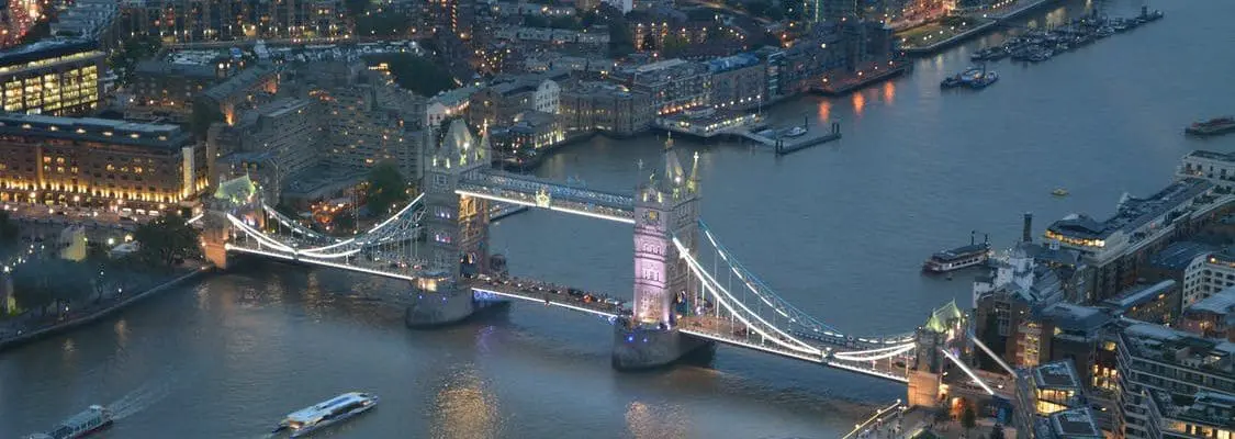 bridge covered in lights over river at night-time