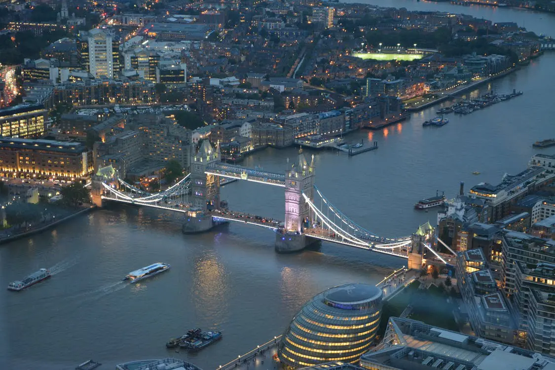 bridge covered in lights over river at night-time