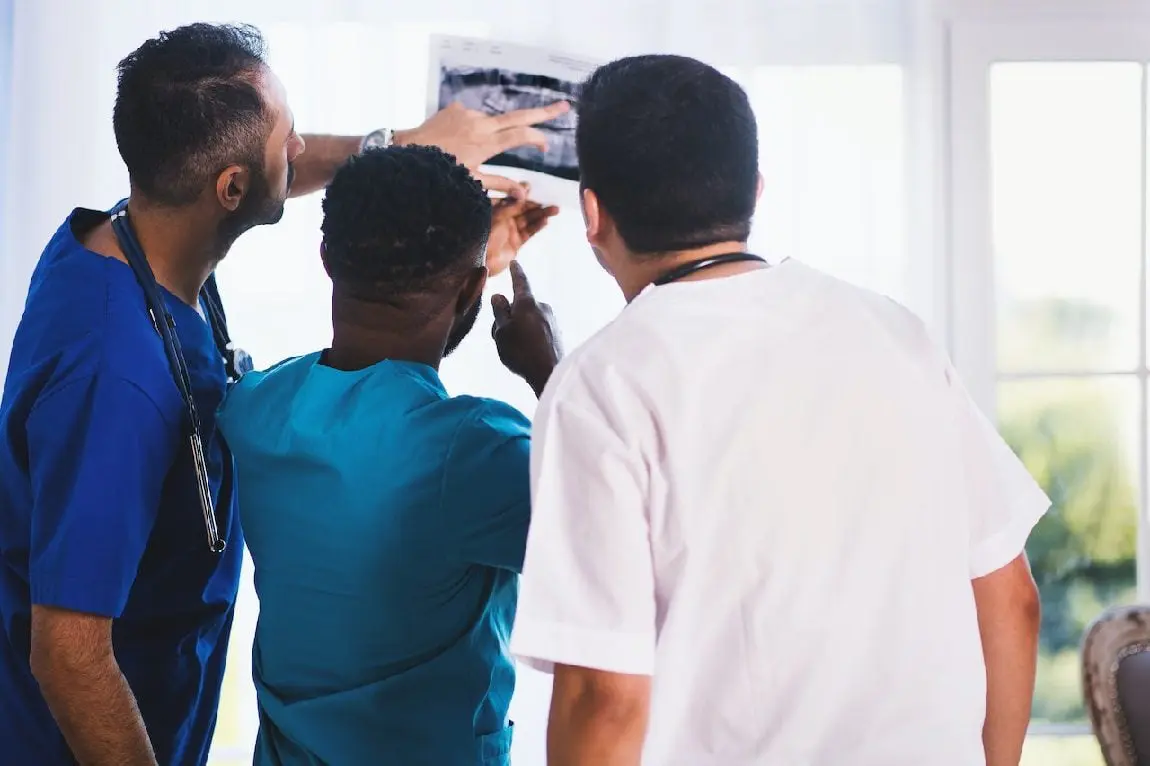 Three nurses looking at x-ray