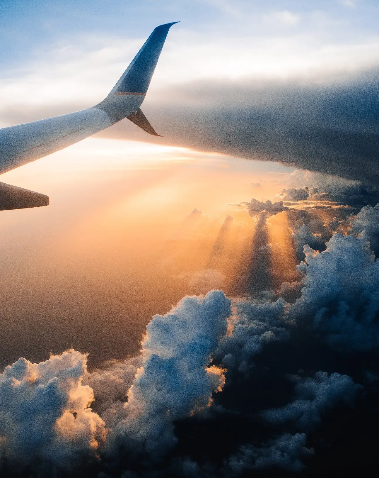 Clouds from above, with plane wing.