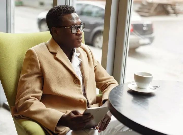 Business in holding tablet in cafe