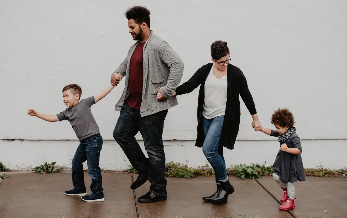 Family walking in a line, hand in hand.