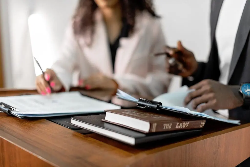 close up of two people using clipboards and legal books