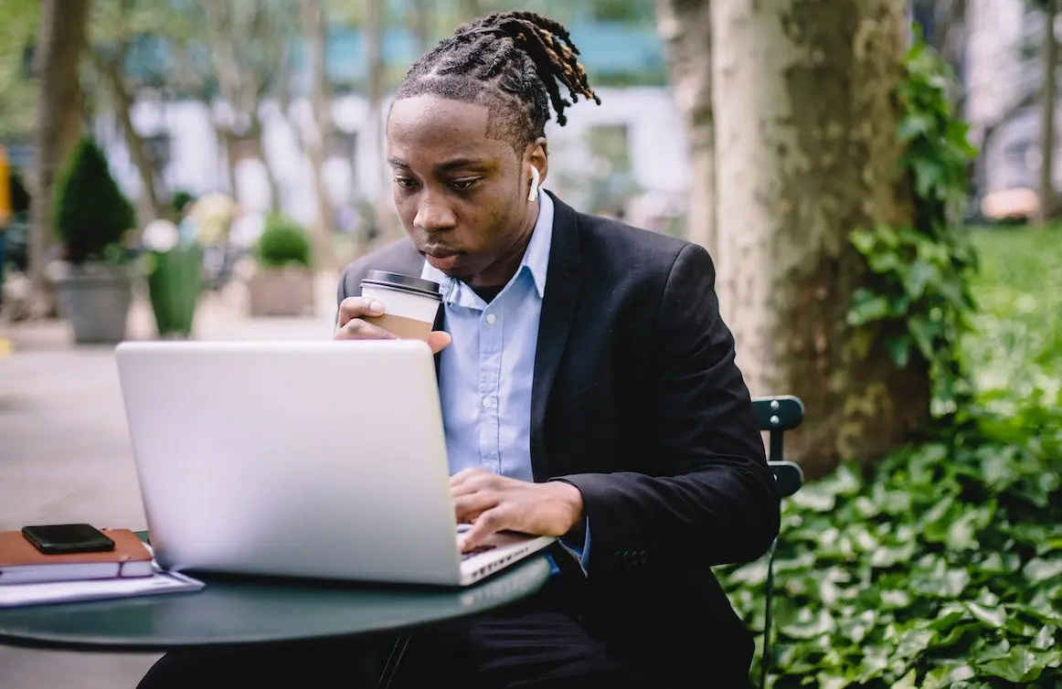 Man on laptop, drinking coffee