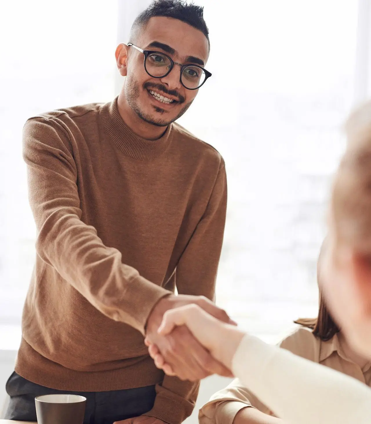 someone shaking another person to represent a compensated employee