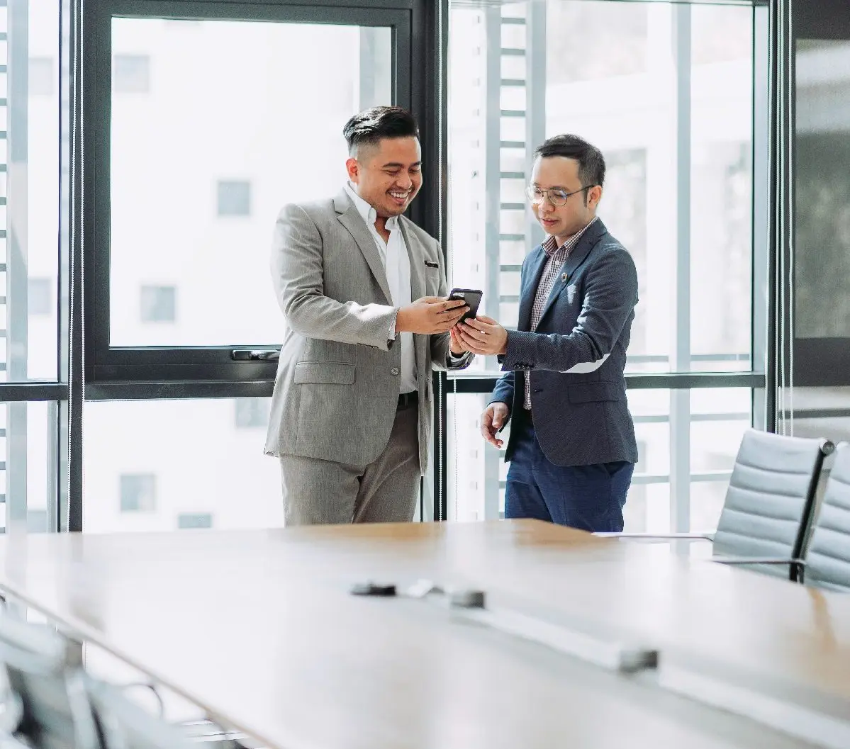 Man showing colleague smartphone.