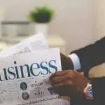 a man holding a business newspaper