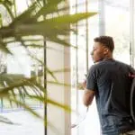 Student stepping outside, through glass door