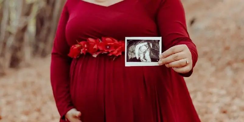 Pregnant woman holding ultrasound