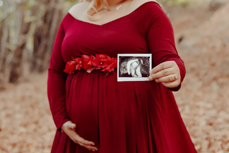 Pregnant woman holding ultrasound