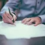 Man completing form on table