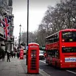 Red double-decker bus next to phone booth