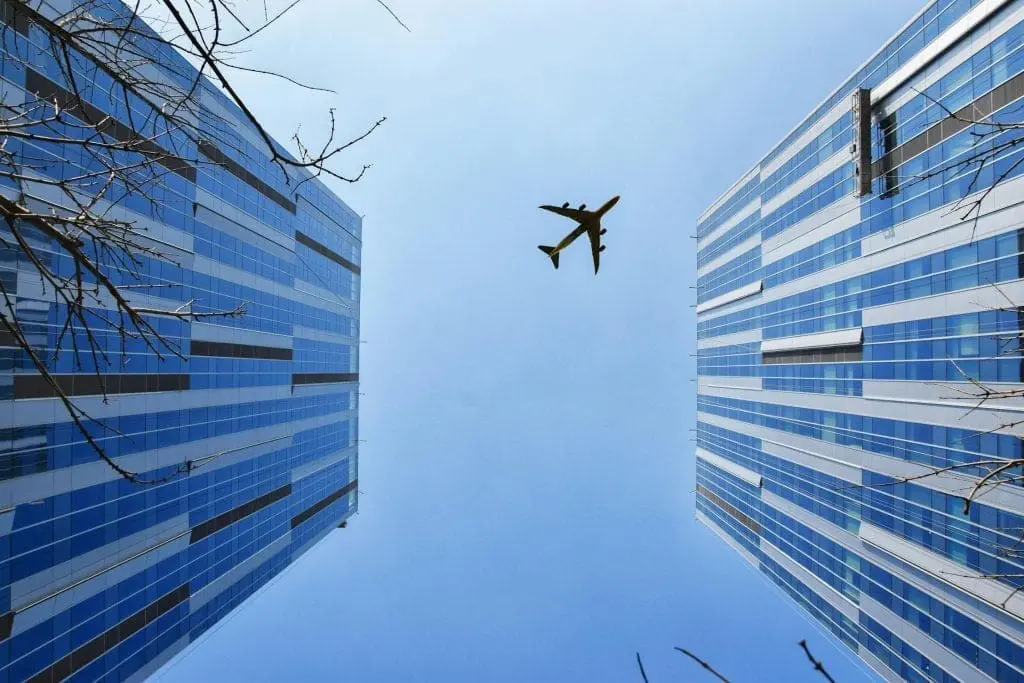 an airplane fly over high rise buildings