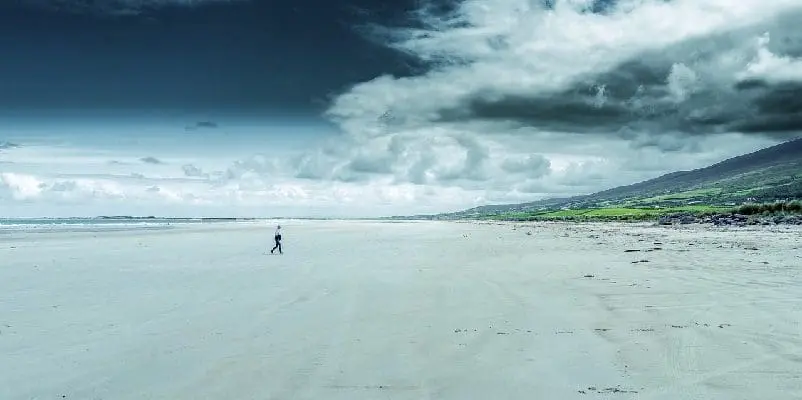 A lone person walking up the beach