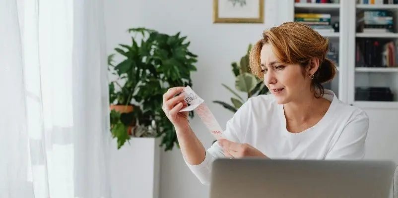 Woman looking at cost of items on a receipt