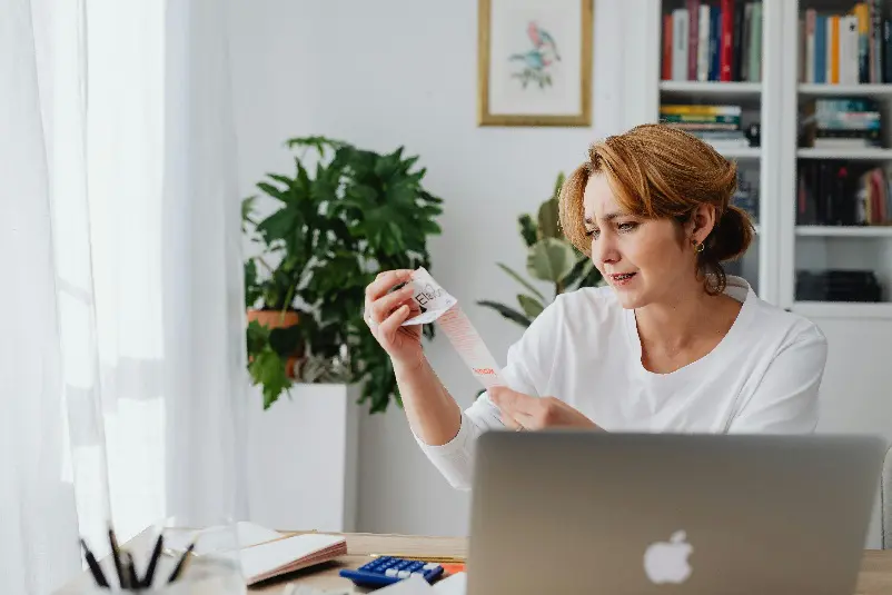 Woman looking at cost of items on a receipt