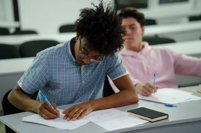 Man writing notes in class
