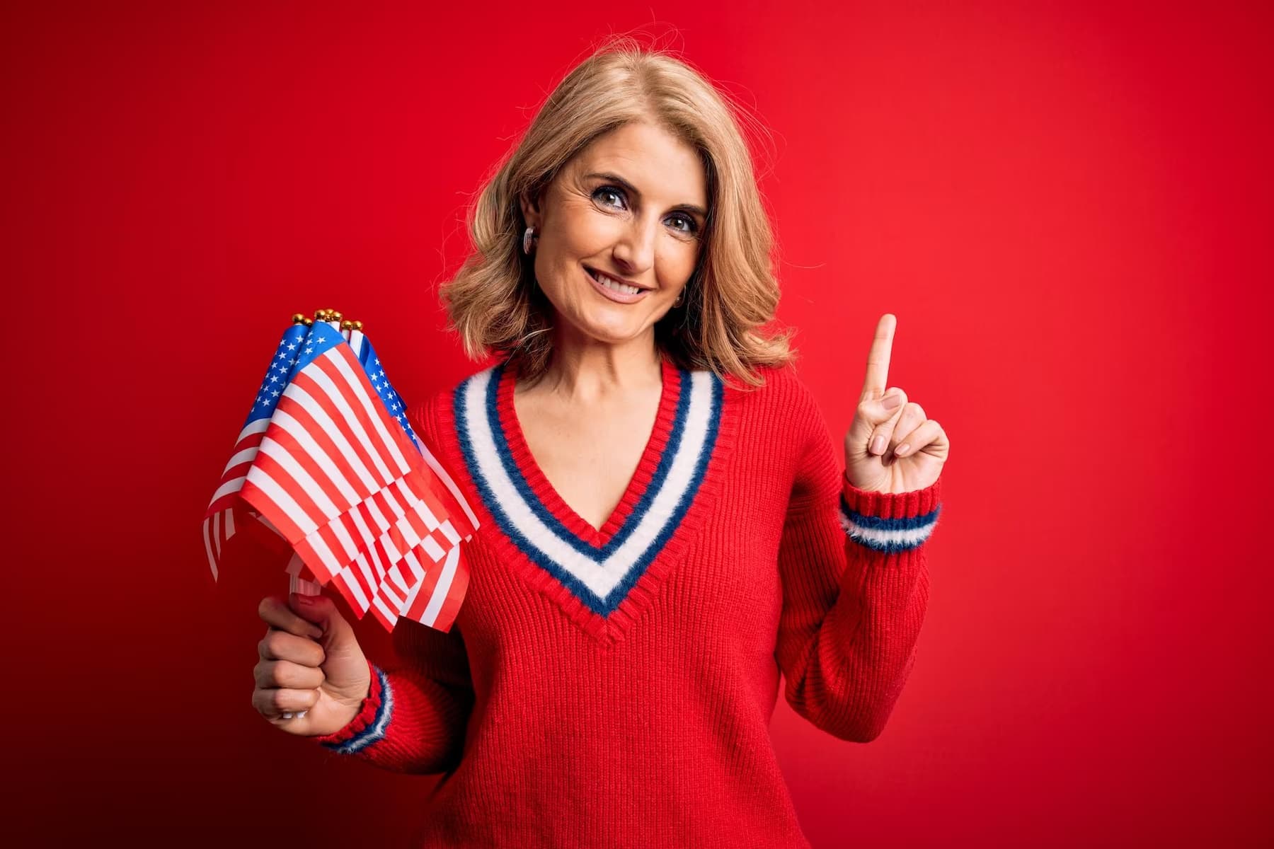 a woman in red holding American flags