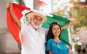two Mexican people with a flag of Mexico