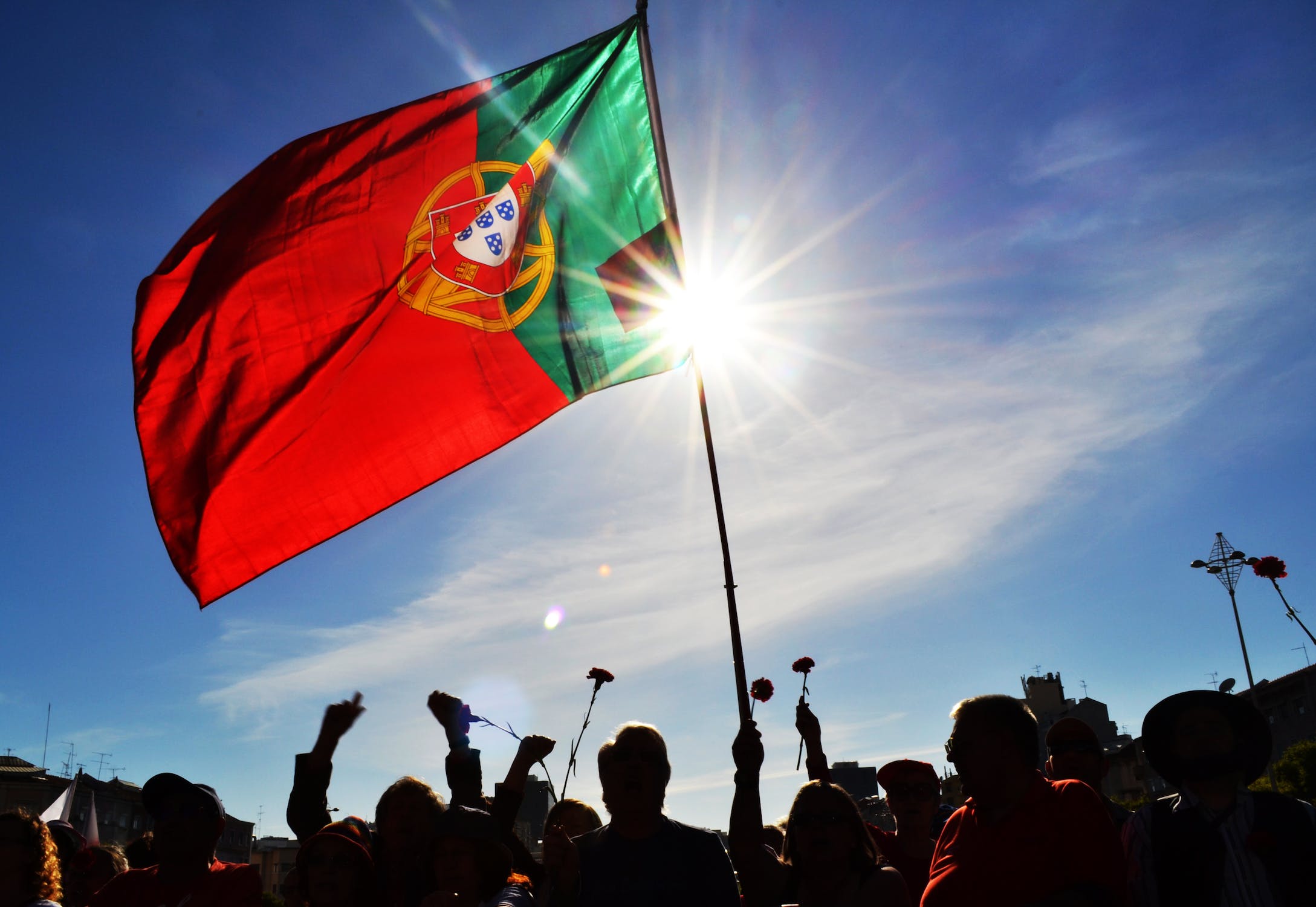 a group of people under a flag of Portugal