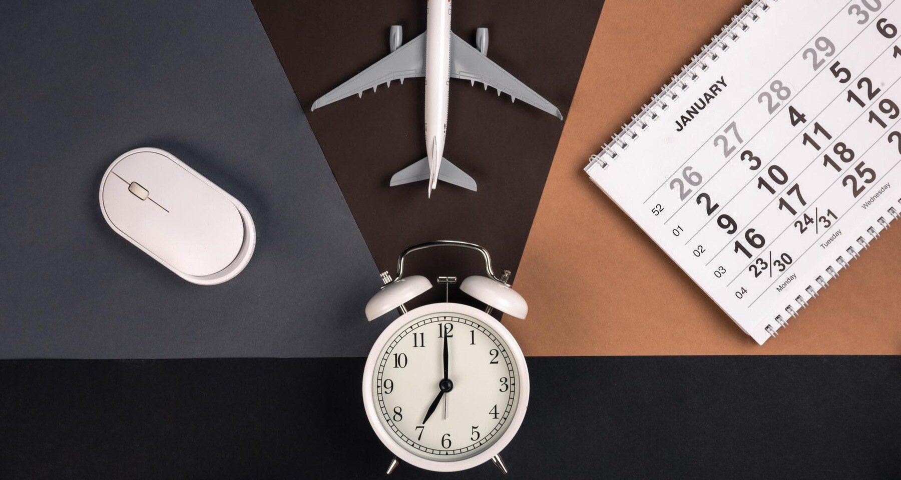 an alarm clock, computer mouse, calendar and an airplane toy