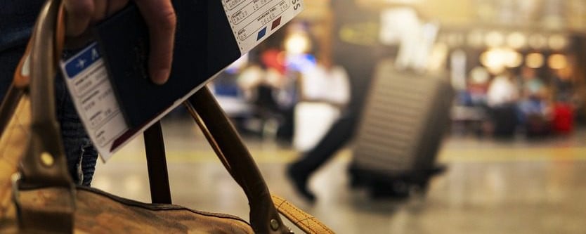 a traveler holding a passport and boarding pass in an airport