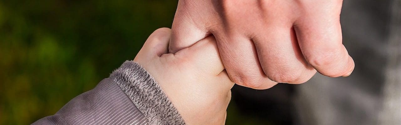 a parent holding hands with a child