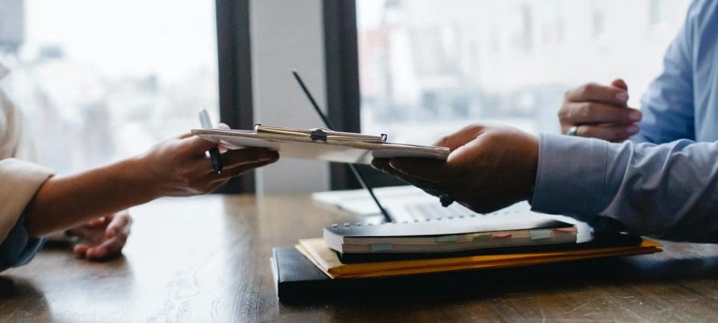 two people handing documents