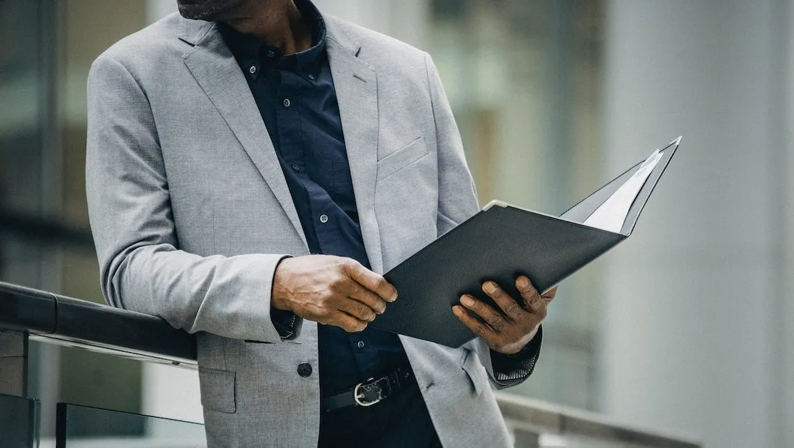 Man in suit jacket holding folder