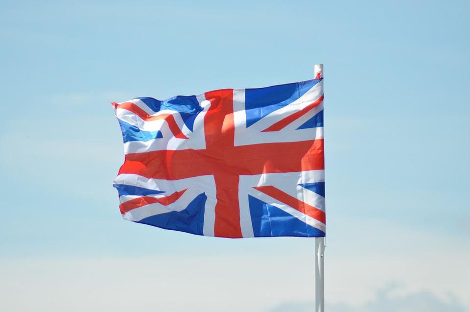 red, white and blue flag flying against a blue sky