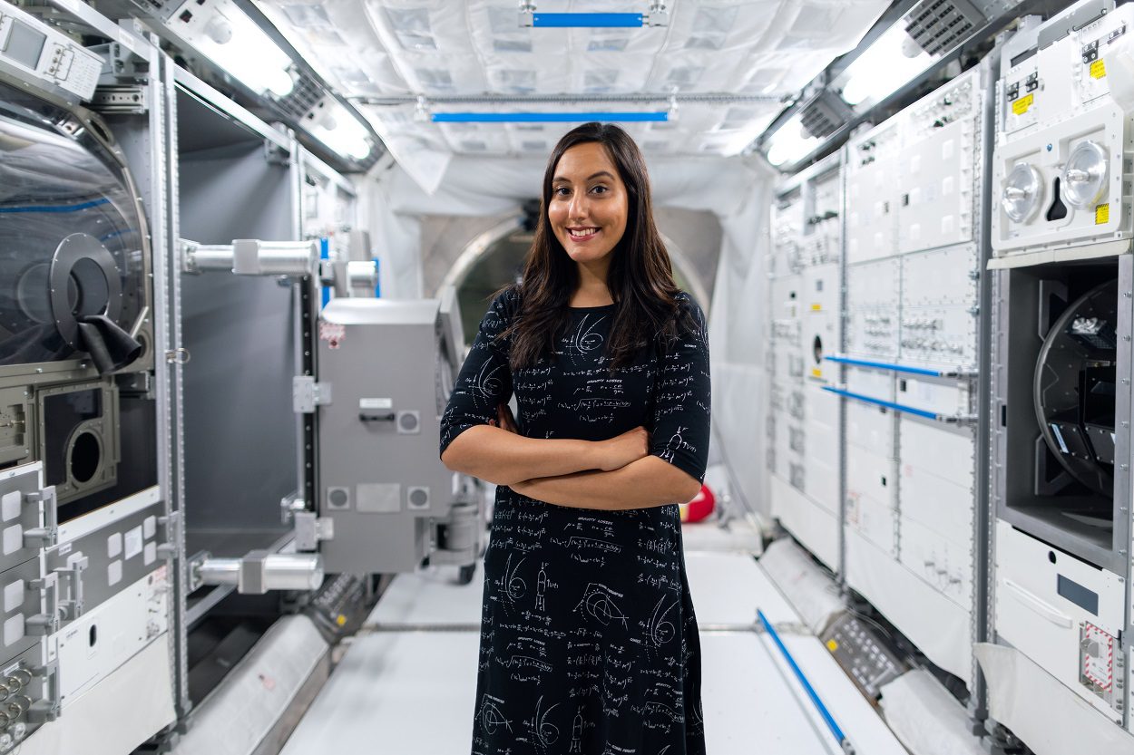 Woman standing and smiling in space station